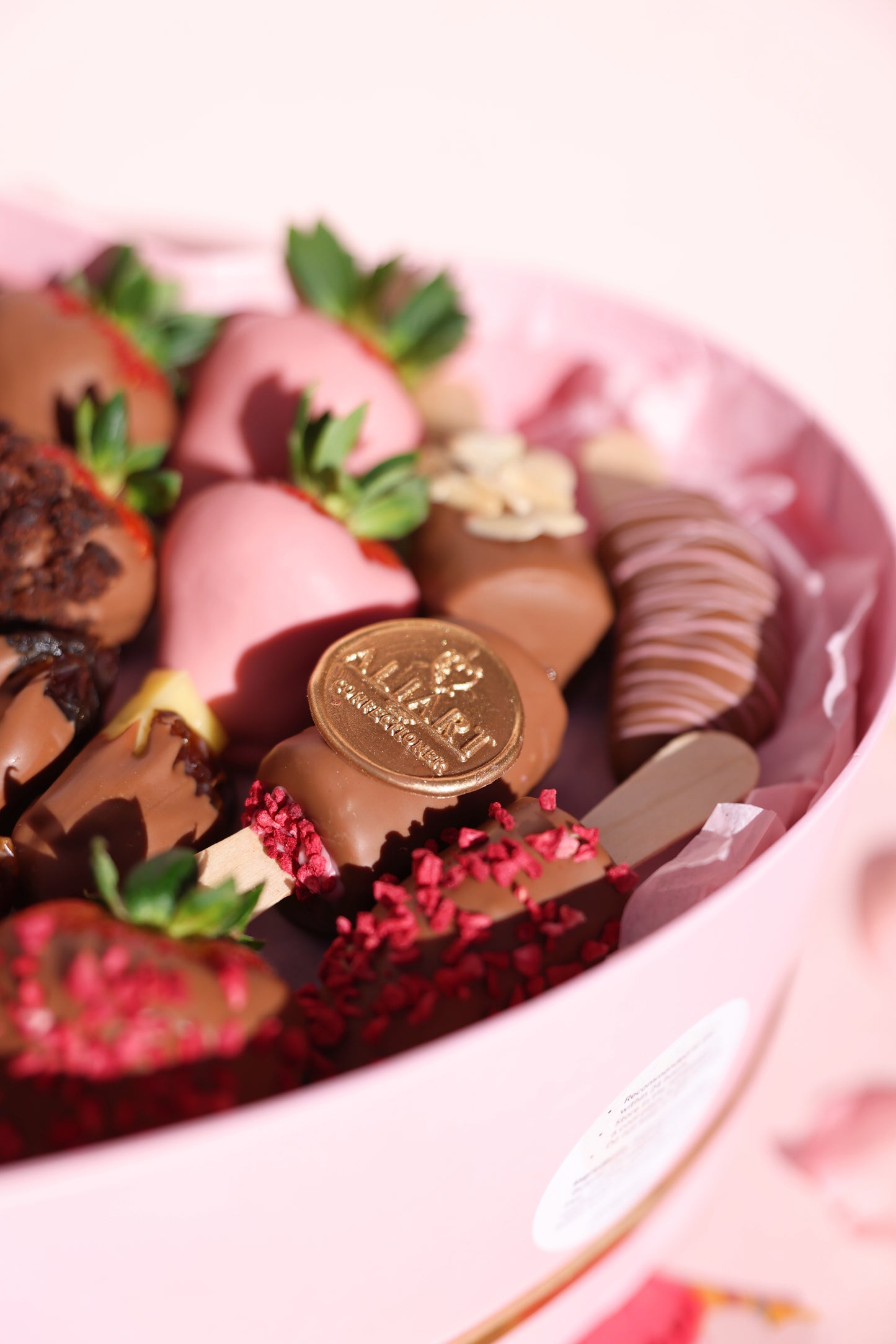 A beautifully arranged box filled with chocolate-covered strawberries, bananas, and dates, showcasing a delicious assortment of fresh fruits and Belgian chocolate.
