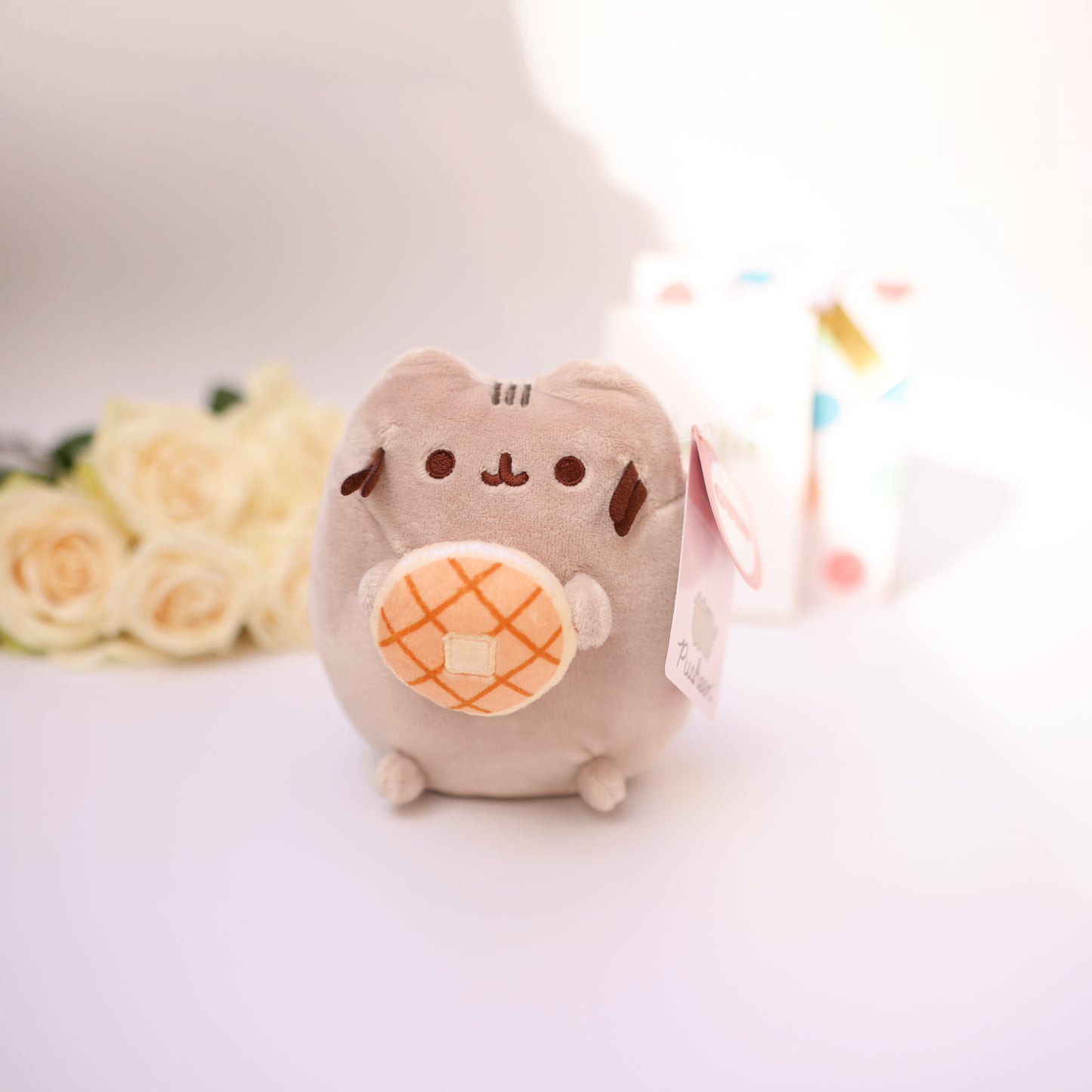 Cute plush cat with a small donut, soft kawaii-style toy.