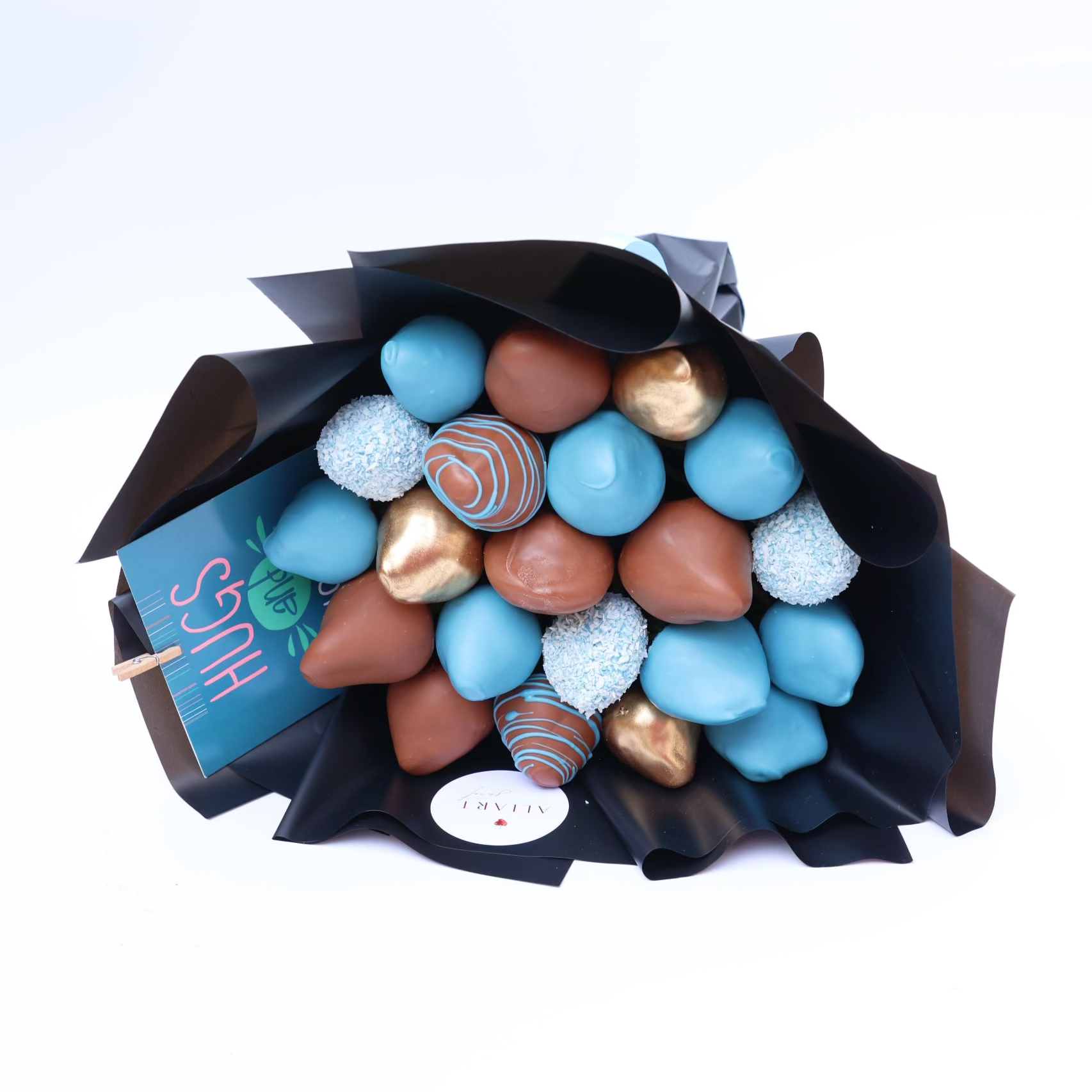 Bouquet of assorted chocolates including blue, brown, and gold candies in a black paper wrap on a white background.