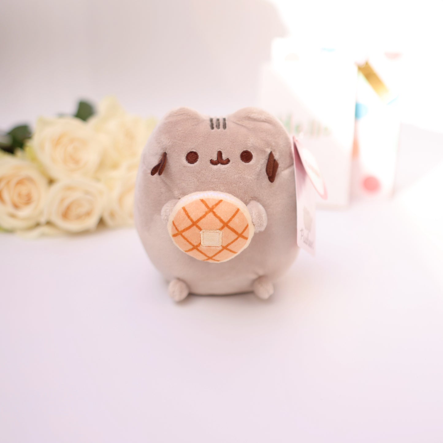 Adorable plush cat with a donut, perfect as a cute add-on to flowers or chocolate gifts.