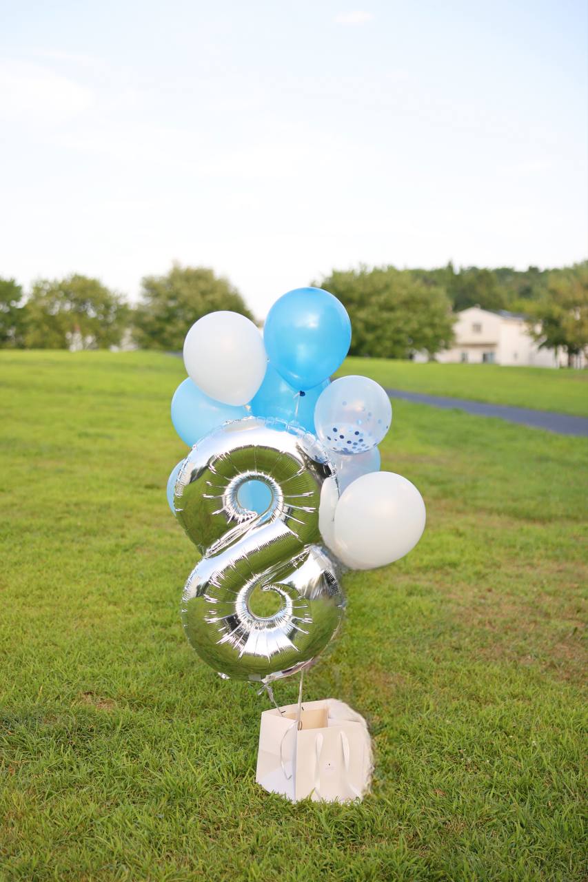 Celebratory setup with a custom number balloon surrounded by vibrant helium balloons for a special occasion