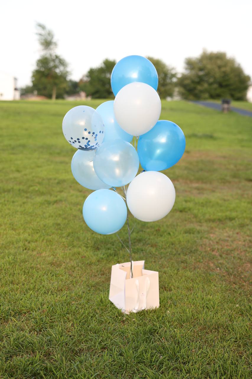 Party decoration featuring a prominent number balloon alongside a collection of cheerful helium balloons